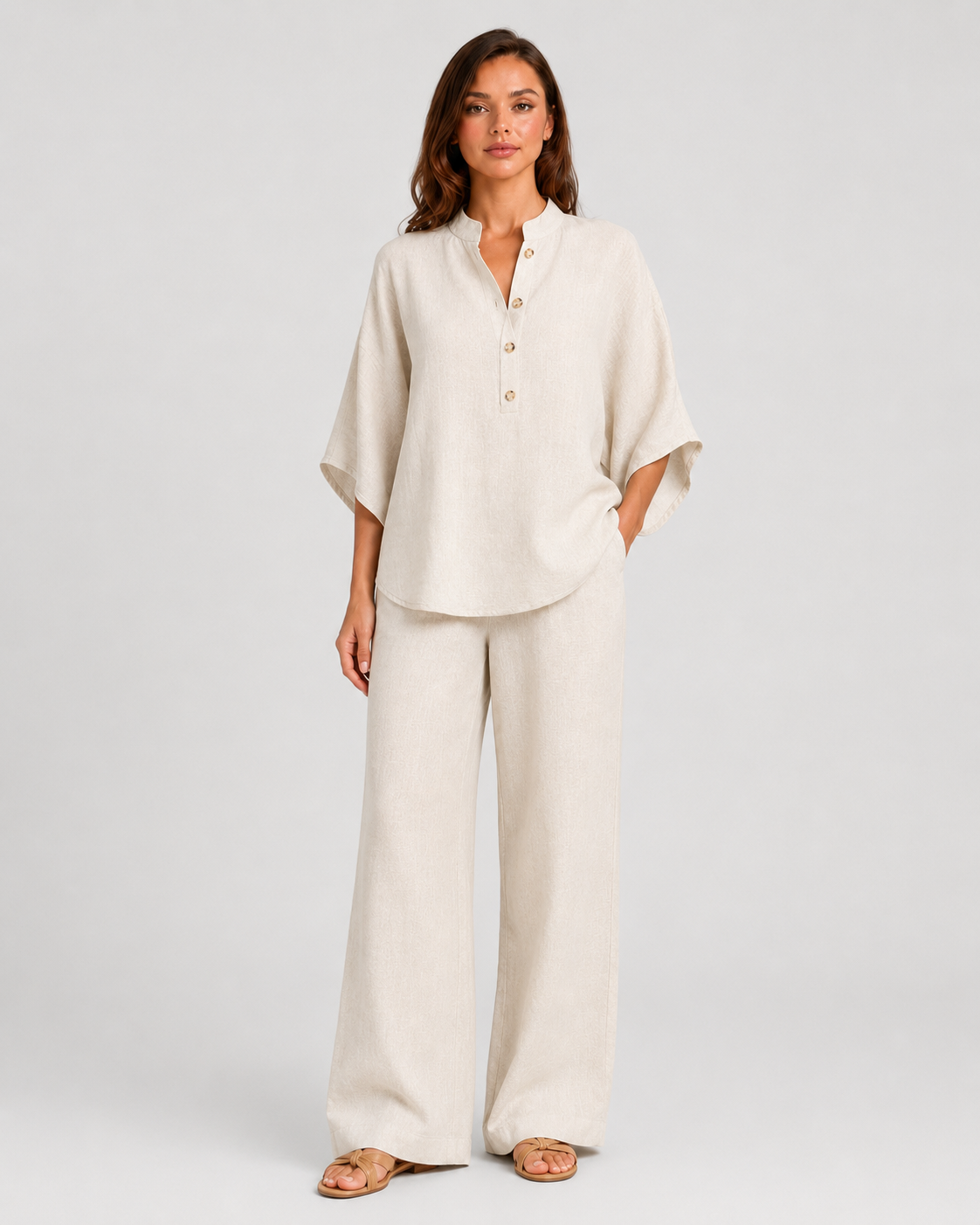 Woman wearing a neutral linen blend two-piece set featuring a button-up shirt and relaxed wide-leg trousers, styled for effortless warm-weather elegance.