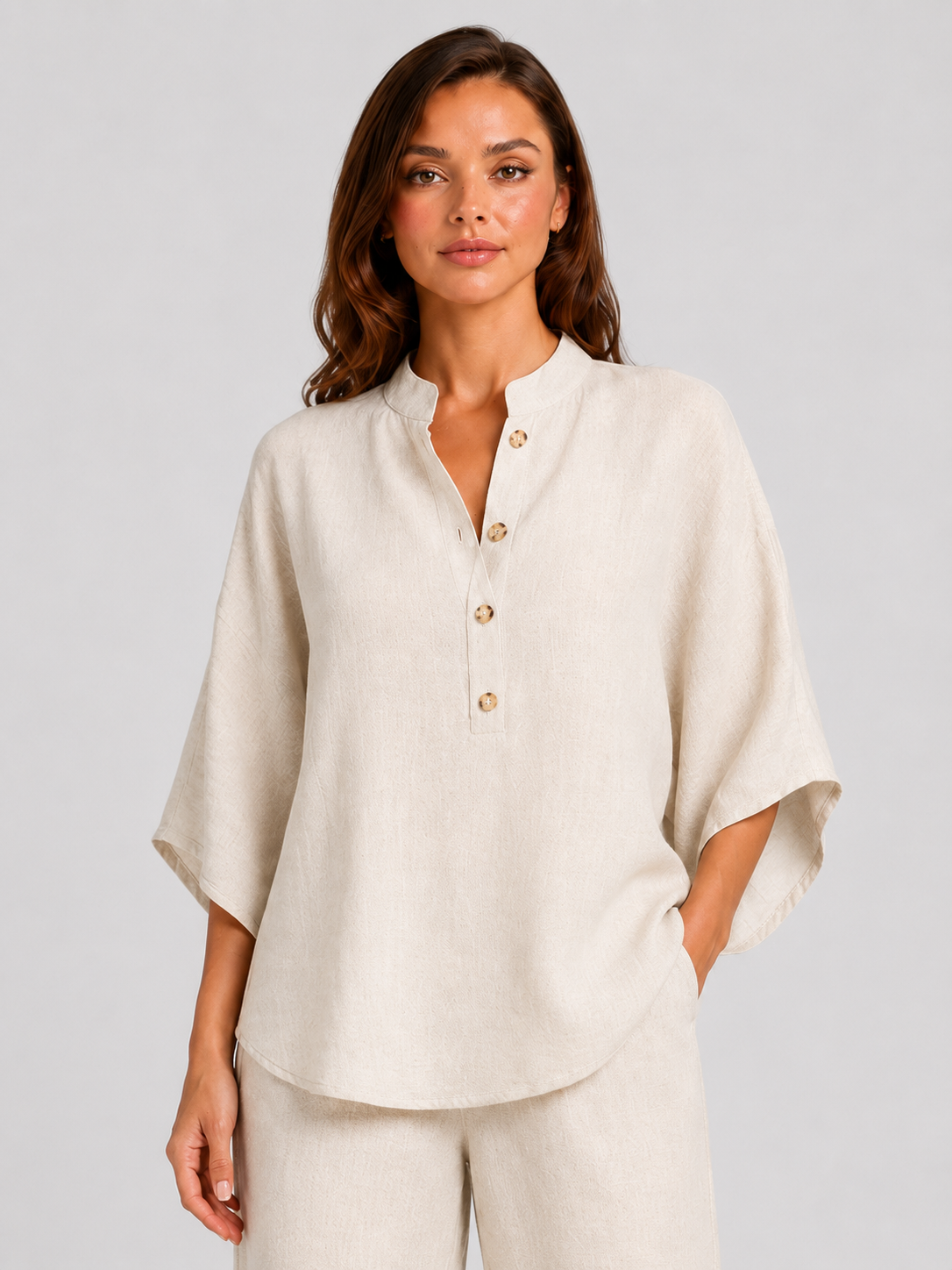 Woman wearing a neutral linen blend two-piece set featuring a button-up shirt and relaxed wide-leg trousers, styled for effortless warm-weather elegance.