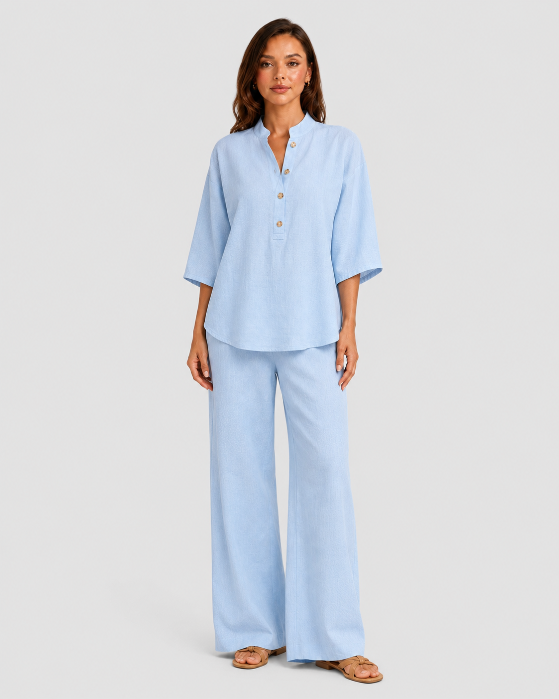 Woman wearing a neutral linen blend two-piece set featuring a button-up shirt and relaxed wide-leg trousers, styled for effortless warm-weather elegance.