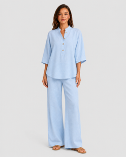 Woman wearing a neutral linen blend two-piece set featuring a button-up shirt and relaxed wide-leg trousers, styled for effortless warm-weather elegance.