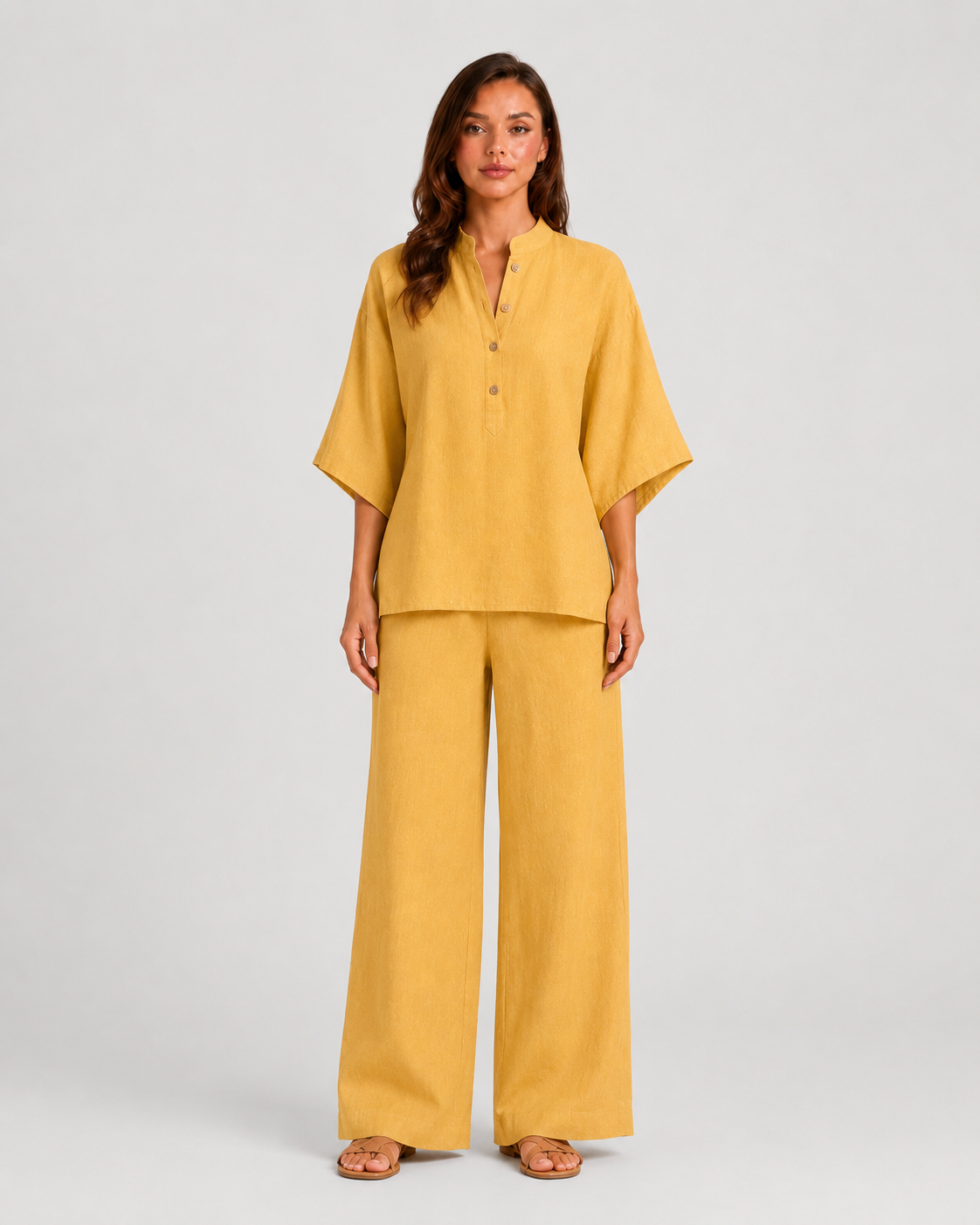 Woman wearing a neutral linen blend two-piece set featuring a button-up shirt and relaxed wide-leg trousers, styled for effortless warm-weather elegance.