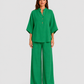 Woman wearing a neutral linen blend two-piece set featuring a button-up shirt and relaxed wide-leg trousers, styled for effortless warm-weather elegance.
