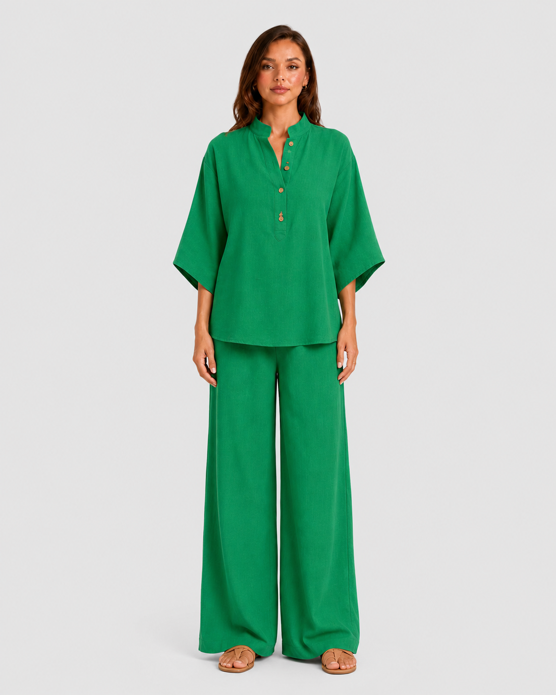 Woman wearing a neutral linen blend two-piece set featuring a button-up shirt and relaxed wide-leg trousers, styled for effortless warm-weather elegance.