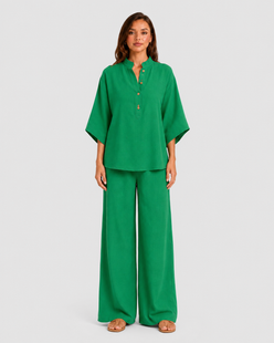 Woman wearing a neutral linen blend two-piece set featuring a button-up shirt and relaxed wide-leg trousers, styled for effortless warm-weather elegance.