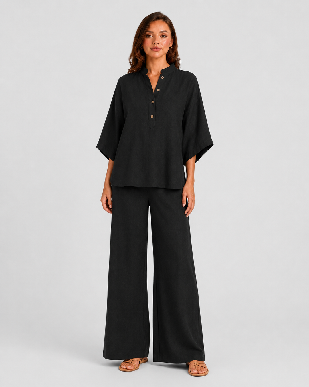 Woman wearing a neutral linen blend two-piece set featuring a button-up shirt and relaxed wide-leg trousers, styled for effortless warm-weather elegance.
