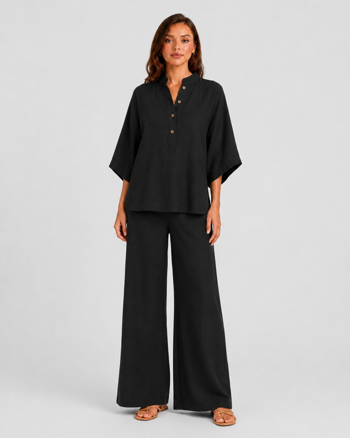 Woman wearing a neutral linen blend two-piece set featuring a button-up shirt and relaxed wide-leg trousers, styled for effortless warm-weather elegance.