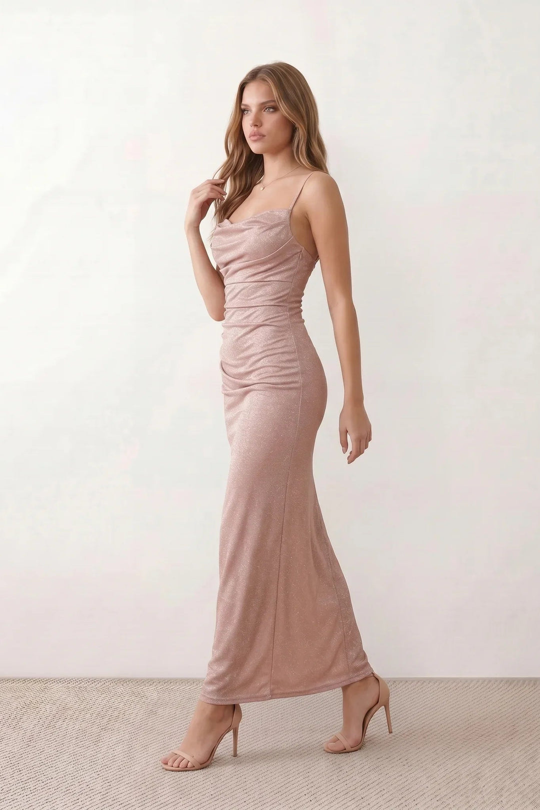 Woman wearing the metallic cowl neck mermaid maxi dress with adjustable spaghetti straps, a ruched bodice, low open back, and shimmering figure-hugging silhouette, perfect for weddings, black-tie events, proms, and formal evening occasions.