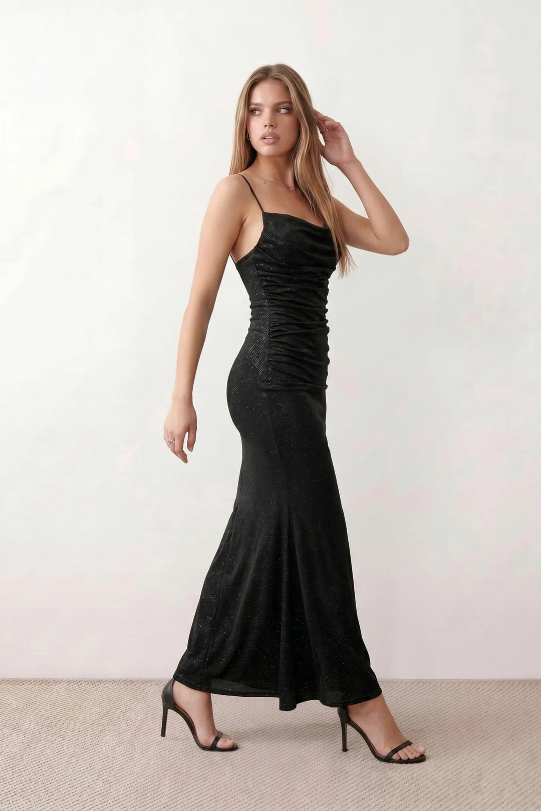 Woman wearing the metallic cowl neck mermaid maxi dress with adjustable spaghetti straps, a ruched bodice, low open back, and shimmering figure-hugging silhouette, perfect for weddings, black-tie events, proms, and formal evening occasions.