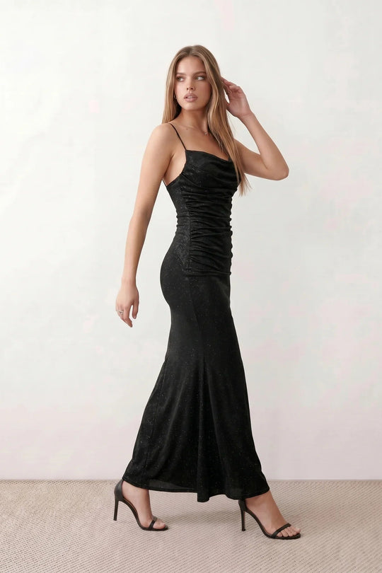 Woman wearing the metallic cowl neck mermaid maxi dress with adjustable spaghetti straps, a ruched bodice, low open back, and shimmering figure-hugging silhouette, perfect for weddings, black-tie events, proms, and formal evening occasions.