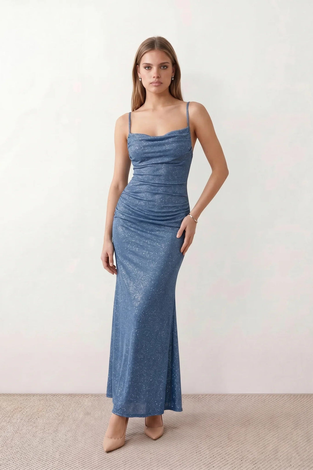 Woman wearing the metallic cowl neck mermaid maxi dress with adjustable spaghetti straps, a ruched bodice, low open back, and shimmering figure-hugging silhouette, perfect for weddings, black-tie events, proms, and formal evening occasions.