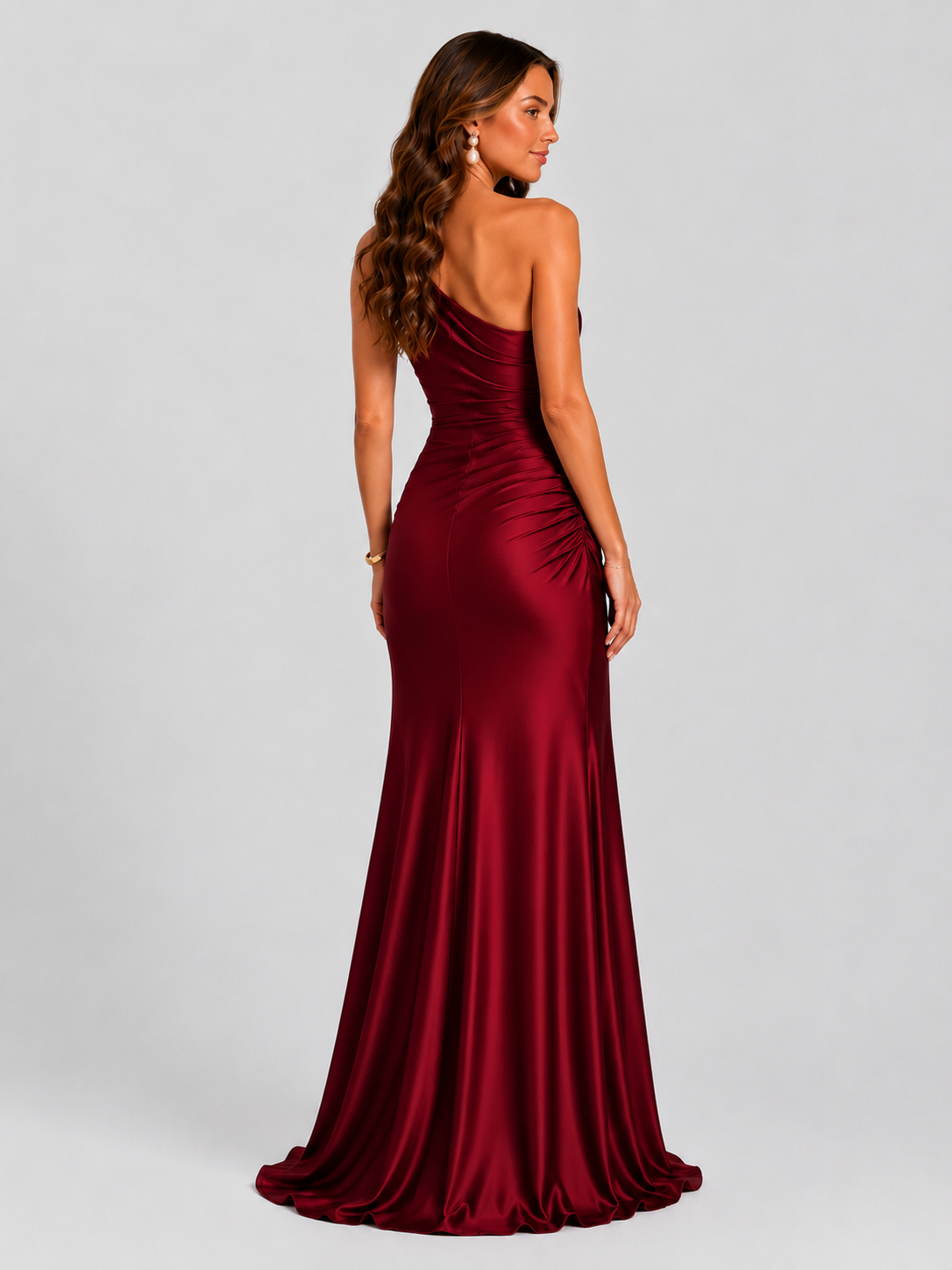Woman wearing a one-shoulder satin maxi dress with a fitted stretch crepe bodice, asymmetric dropped waist, and elegant draped hip detailing.