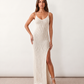 Woman wearing the Flora openwork spaghetti strap maxi dress in a pointelle knit with a V-neckline, adjustable straps, low back, and side slit for an elegant, airy silhouette.
