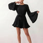 Woman wearing the Pleated Ruffle Detail Mini Dress featuring an all-over pleated design, flowing bell sleeves, a round neckline, elasticated waist with a self-tie sash, and a feminine ruffle hem, perfect for weddings, garden parties, race days, and elegant occasions.