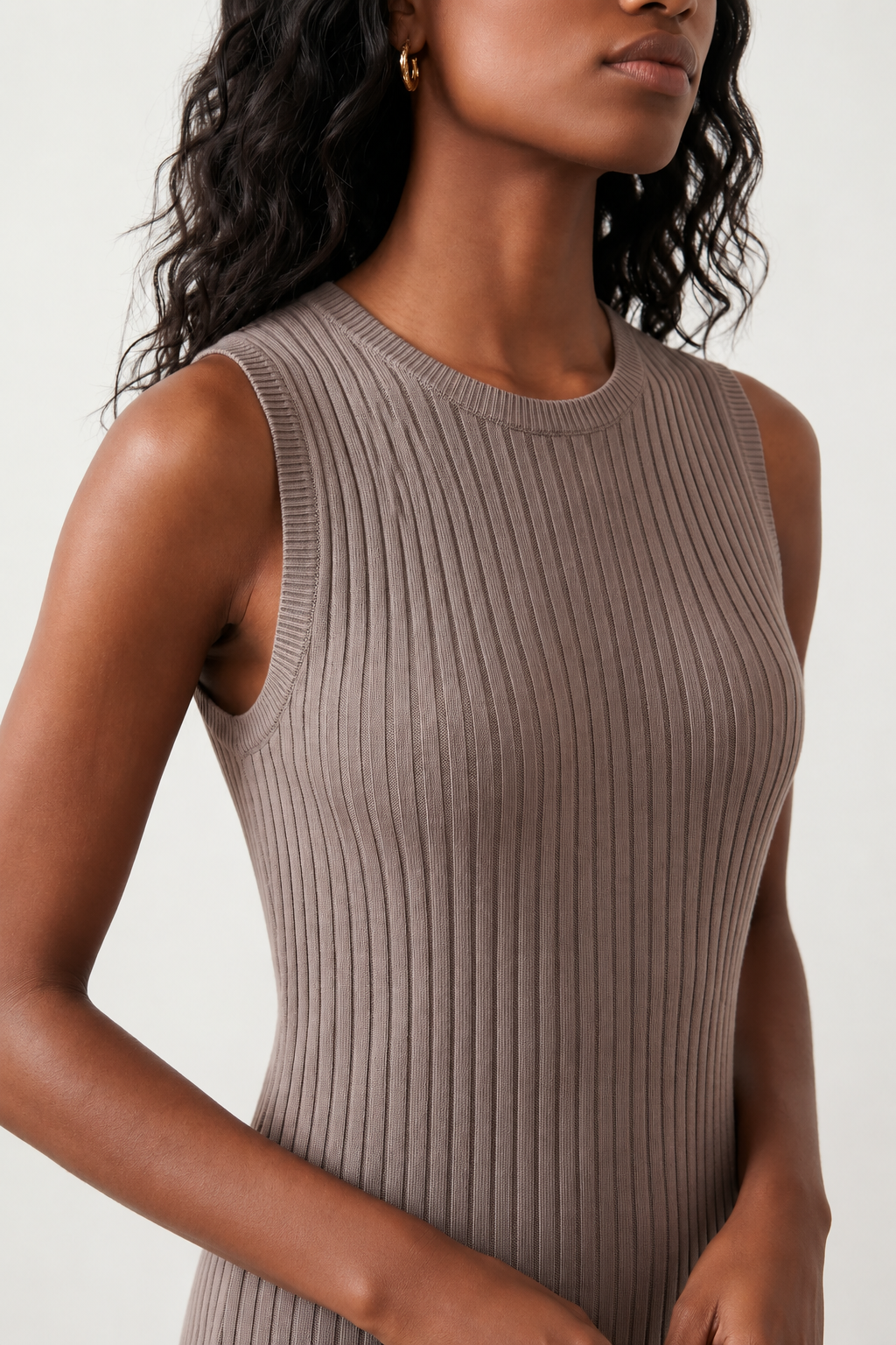 Woman wearing the Raina ribbed fitted midi dress in a sleeveless bodycon design with a round neckline, wide-rib knit texture and elegant side slit, styled as a sophisticated occasion dress.