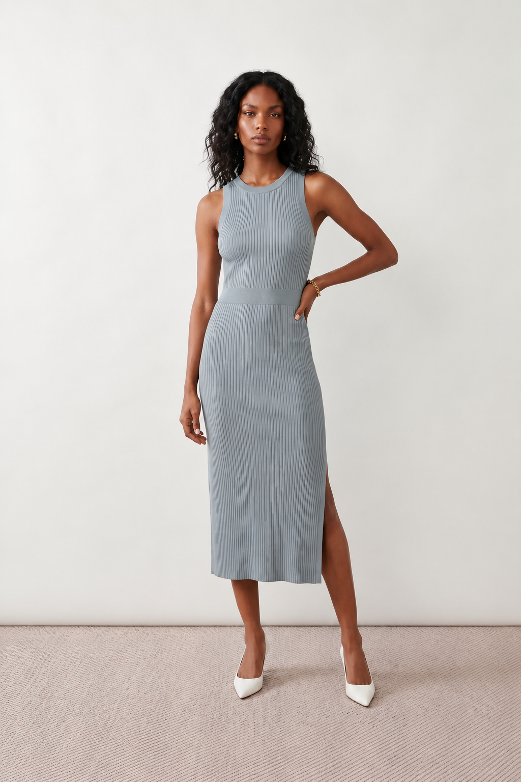 Woman wearing the Raina ribbed fitted midi dress in a sleeveless bodycon design with a round neckline, wide-rib knit texture and elegant side slit, styled as a sophisticated occasion dress.