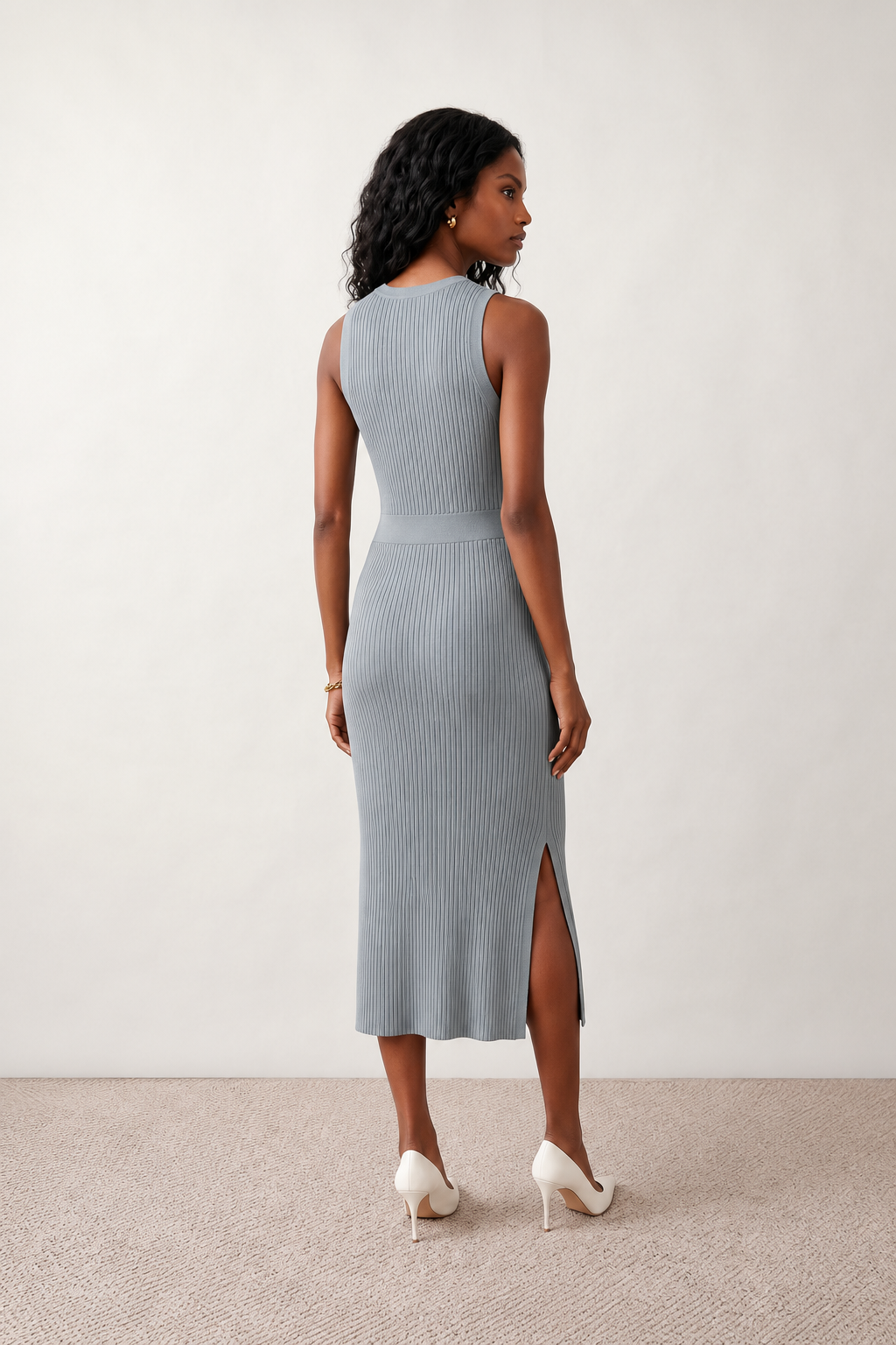 Woman wearing the Raina ribbed fitted midi dress in a sleeveless bodycon design with a round neckline, wide-rib knit texture and elegant side slit, styled as a sophisticated occasion dress.
