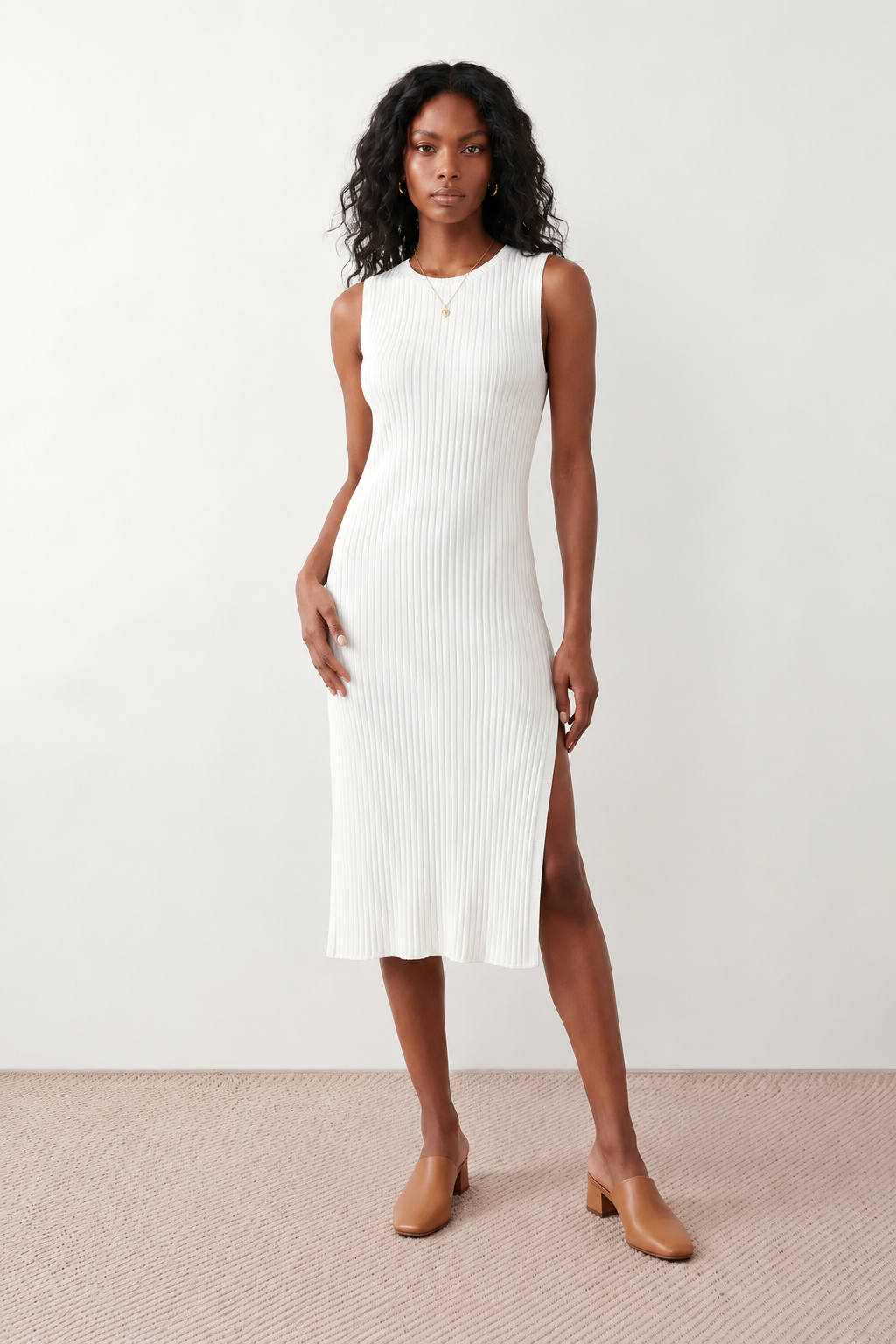 Woman wearing the Raina ribbed fitted midi dress in a sleeveless bodycon design with a round neckline, wide-rib knit texture and elegant side slit, styled as a sophisticated occasion dress.