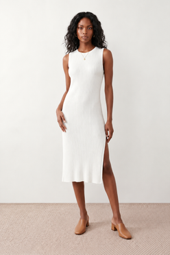 Woman wearing the Raina ribbed fitted midi dress in a sleeveless bodycon design with a round neckline, wide-rib knit texture and elegant side slit, styled as a sophisticated occasion dress.