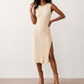 Woman wearing the Raina ribbed fitted midi dress in a sleeveless bodycon design with a round neckline, wide-rib knit texture and elegant side slit, styled as a sophisticated occasion dress.