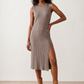 Woman wearing the Raina ribbed fitted midi dress in a sleeveless bodycon design with a round neckline, wide-rib knit texture and elegant side slit, styled as a sophisticated occasion dress.