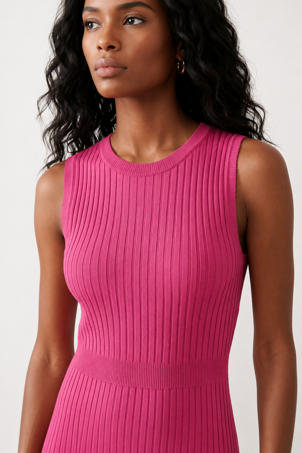 Woman wearing the Raina ribbed fitted midi dress in a sleeveless bodycon design with a round neckline, wide-rib knit texture and elegant side slit, styled as a sophisticated occasion dress.