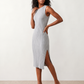 Woman wearing the Raina ribbed fitted midi dress in a sleeveless bodycon design with a round neckline, wide-rib knit texture and elegant side slit, styled as a sophisticated occasion dress.