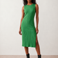 Woman wearing the Raina ribbed fitted midi dress in a sleeveless bodycon design with a round neckline, wide-rib knit texture and elegant side slit, styled as a sophisticated occasion dress.