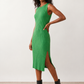 Woman wearing the Raina ribbed fitted midi dress in a sleeveless bodycon design with a round neckline, wide-rib knit texture and elegant side slit, styled as a sophisticated occasion dress.