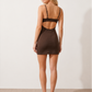 Woman wearing the Roksana rhinestone floral open back mini dress with a square neckline, adjustable spaghetti straps, sparkling floral embellishments, bodycon fit, and statement buckle-back detail, perfect for cocktail parties and evening occasions.