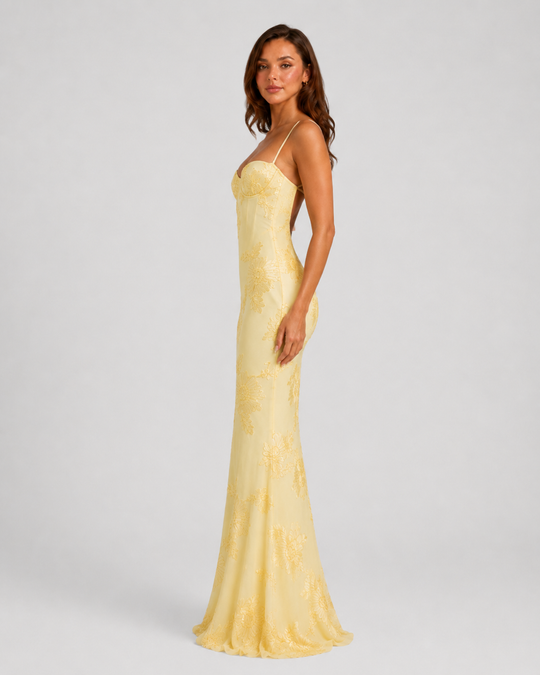 Woman wearing a floral embroidered corset maxi dress with delicate straps and a flowing full-length skirt, styled for weddings and formal occasions.