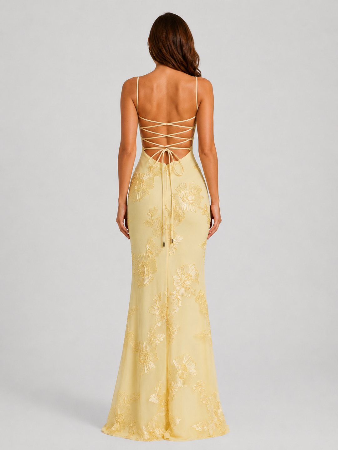 Woman wearing a floral embroidered corset maxi dress with delicate straps and a flowing full-length skirt, styled for weddings and formal occasions.