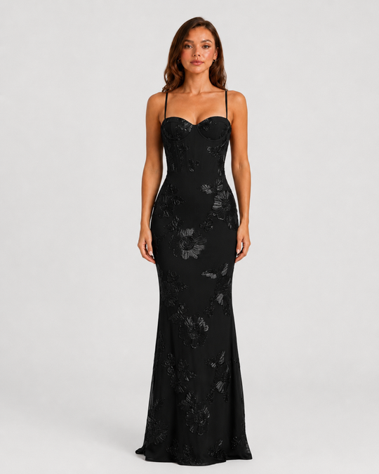 Woman wearing a floral embroidered corset maxi dress with delicate straps and a flowing full-length skirt, styled for weddings and formal occasions.