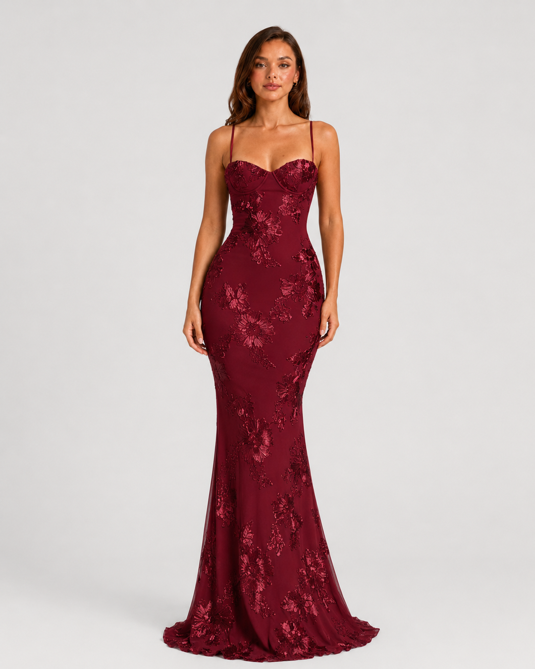 Woman wearing a floral embroidered corset maxi dress with delicate straps and a flowing full-length skirt, styled for weddings and formal occasions.