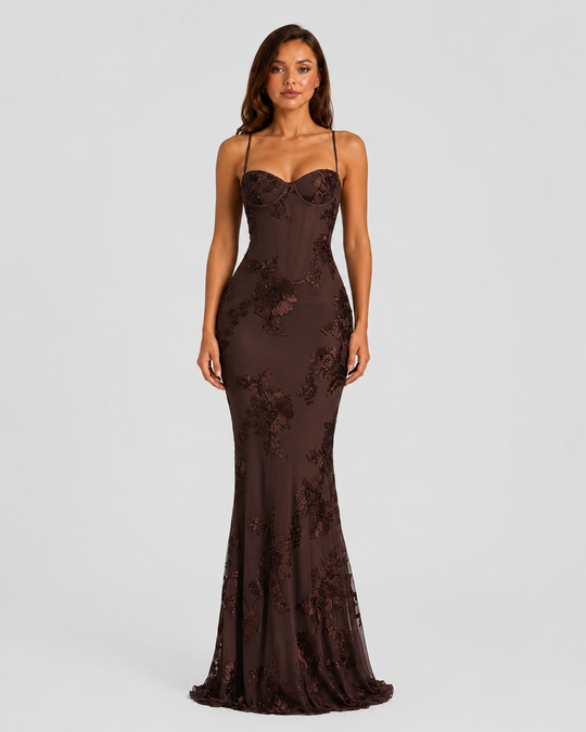 Woman wearing a floral embroidered corset maxi dress with delicate straps and a flowing full-length skirt, styled for weddings and formal occasions.