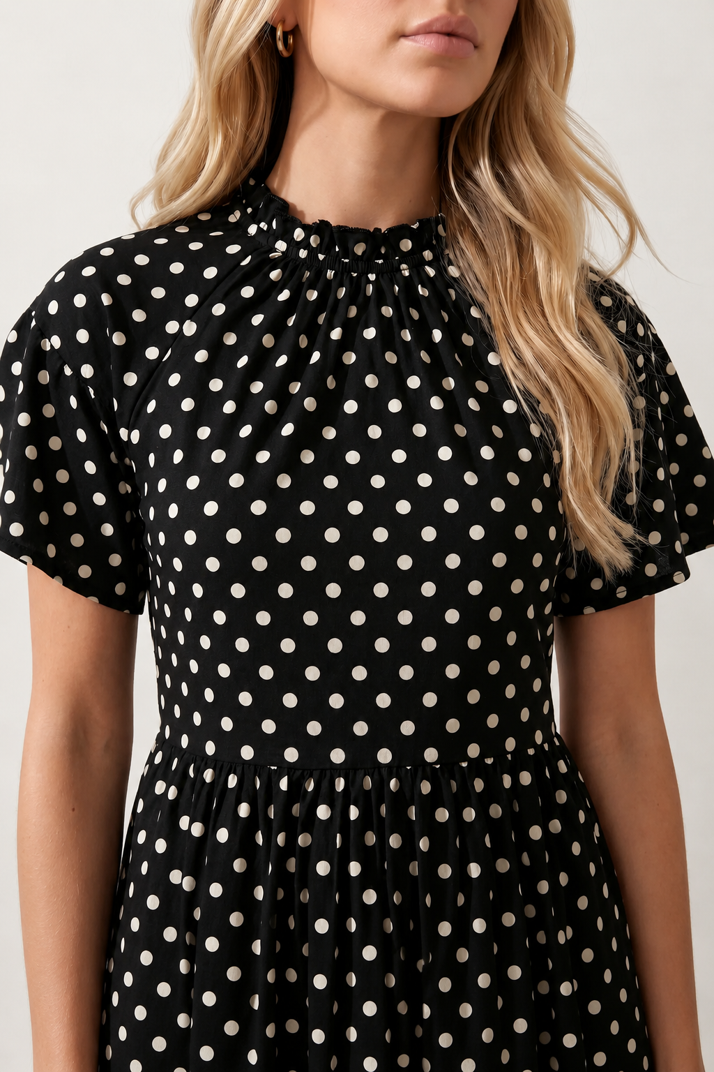 Women's Romy Polka Dot Ruffle Detail Mini Dress in lightweight woven chiffon featuring an all-over polka dot print, ruffled mock neckline, flutter sleeves, defined waist and tiered ruffle mini skirt, ideal for weddings, garden parties and elegant occasion wear.