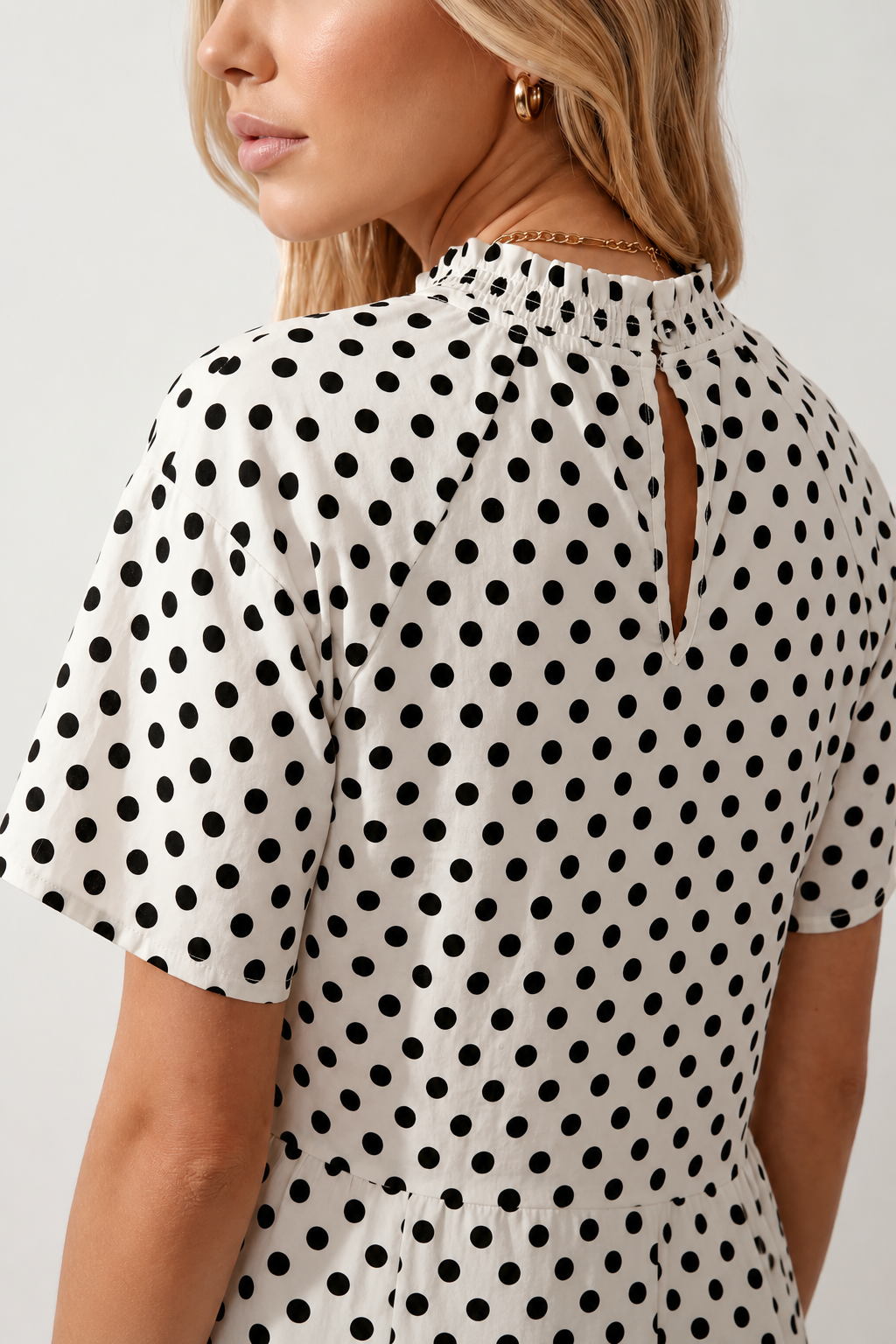 Women's Romy Polka Dot Ruffle Detail Mini Dress in lightweight woven chiffon featuring an all-over polka dot print, ruffled mock neckline, flutter sleeves, defined waist and tiered ruffle mini skirt, ideal for weddings, garden parties and elegant occasion wear.