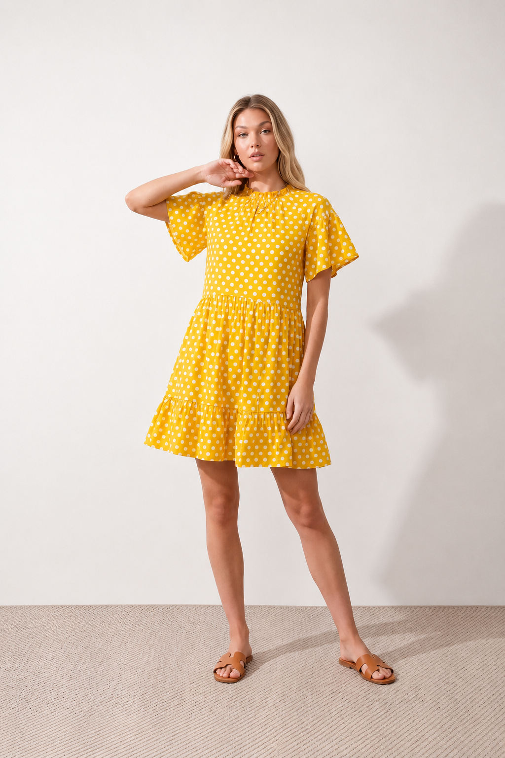Women's Romy Polka Dot Ruffle Detail Mini Dress in lightweight woven chiffon featuring an all-over polka dot print, ruffled mock neckline, flutter sleeves, defined waist and tiered ruffle mini skirt, ideal for weddings, garden parties and elegant occasion wear.