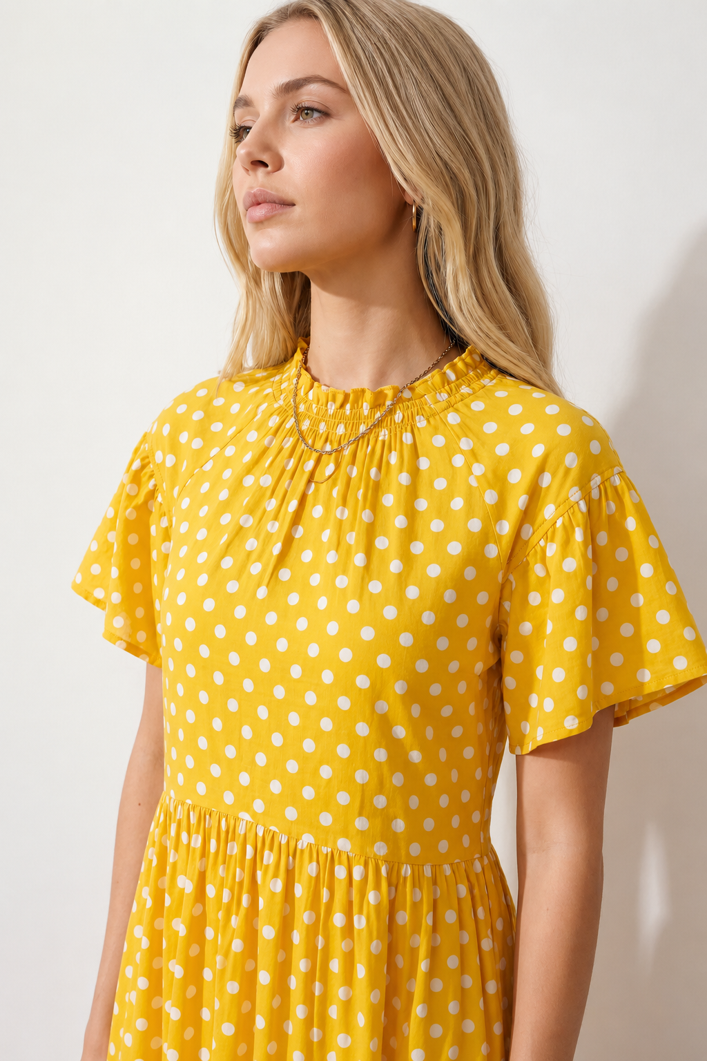 Women's Romy Polka Dot Ruffle Detail Mini Dress in lightweight woven chiffon featuring an all-over polka dot print, ruffled mock neckline, flutter sleeves, defined waist and tiered ruffle mini skirt, ideal for weddings, garden parties and elegant occasion wear.