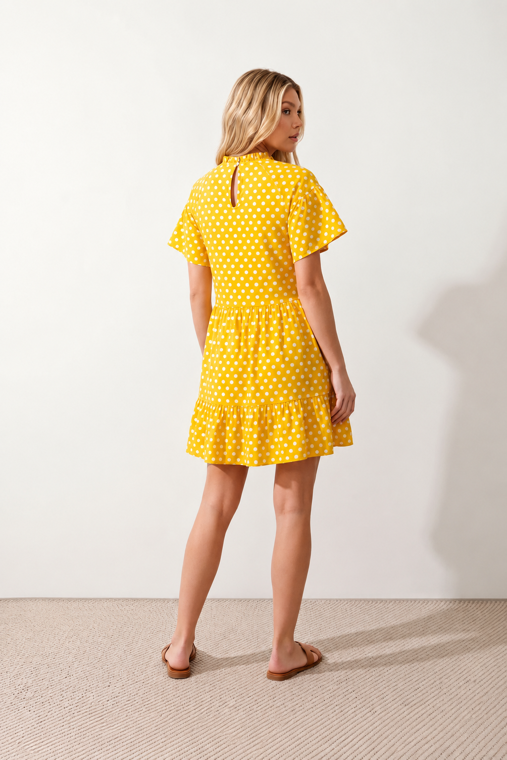 Women's Romy Polka Dot Ruffle Detail Mini Dress in lightweight woven chiffon featuring an all-over polka dot print, ruffled mock neckline, flutter sleeves, defined waist and tiered ruffle mini skirt, ideal for weddings, garden parties and elegant occasion wear.