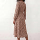 Woman wearing the Rosa Animal Print Wrap Front Midi Dress in a flowing leopard print fabric, featuring a wrap-front V-neckline, adjustable self-tie waist, long sleeves with gathered elasticated cuffs, a high-low midi hem, and a front slit, styled for weddings, cocktail parties, and elegant occasions.