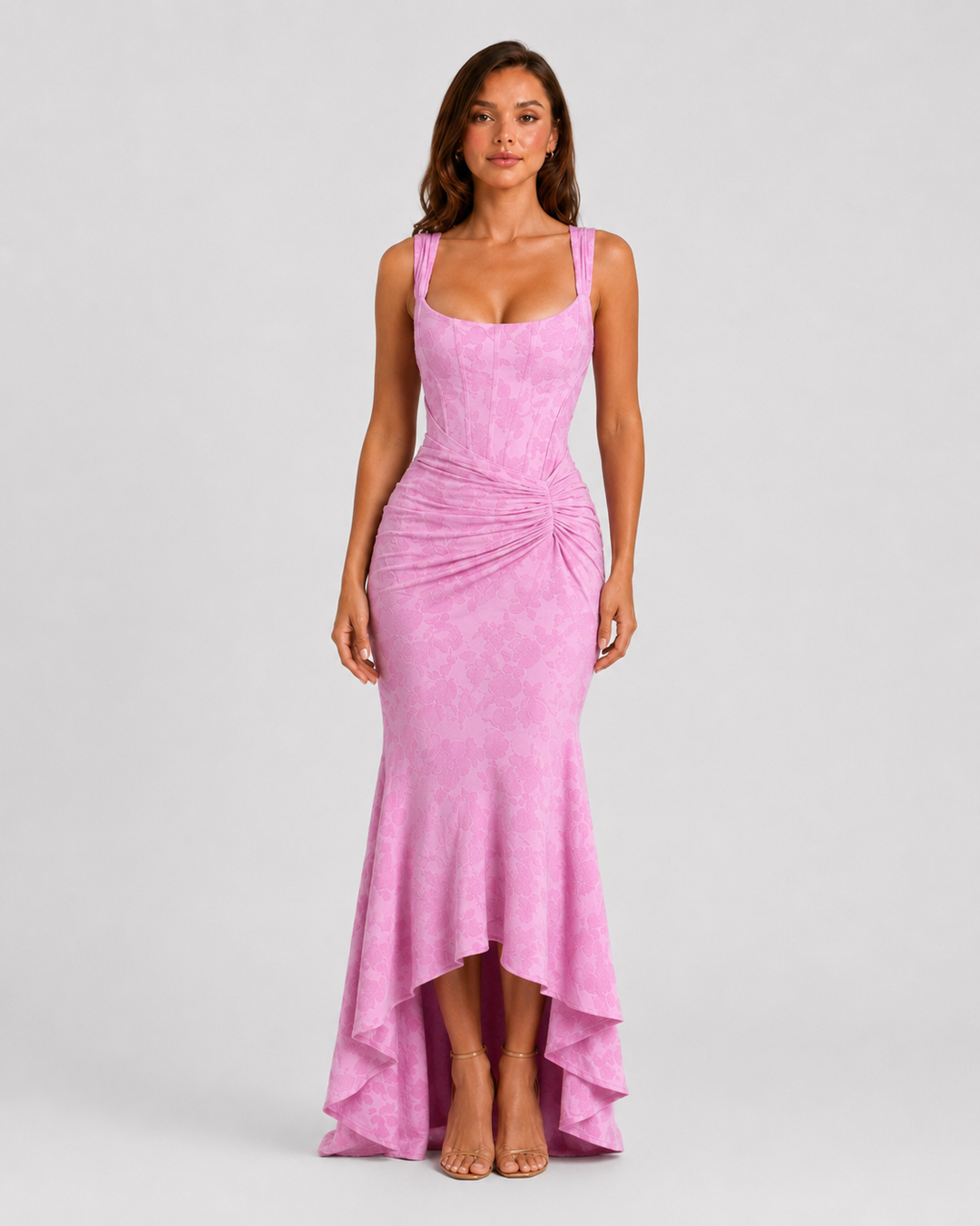 Woman wearing a textured floral corset maxi dress featuring a structured bodice, ruched waist, and dramatic high-low fishtail hem for elegant evening occasions.