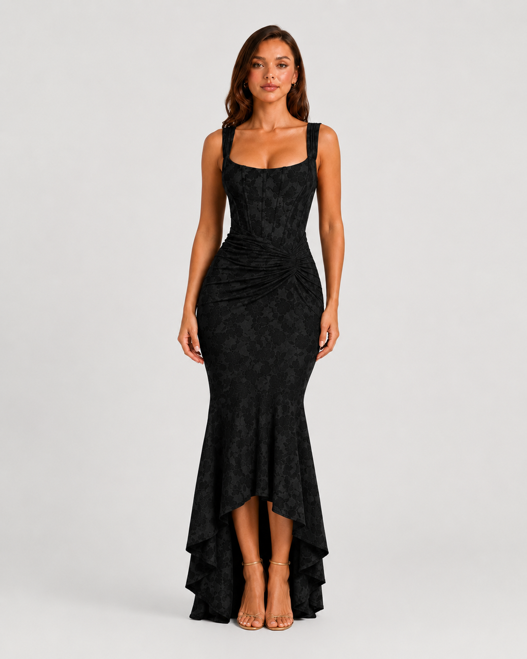 Woman wearing a textured floral corset maxi dress featuring a structured bodice, ruched waist, and dramatic high-low fishtail hem for elegant evening occasions.