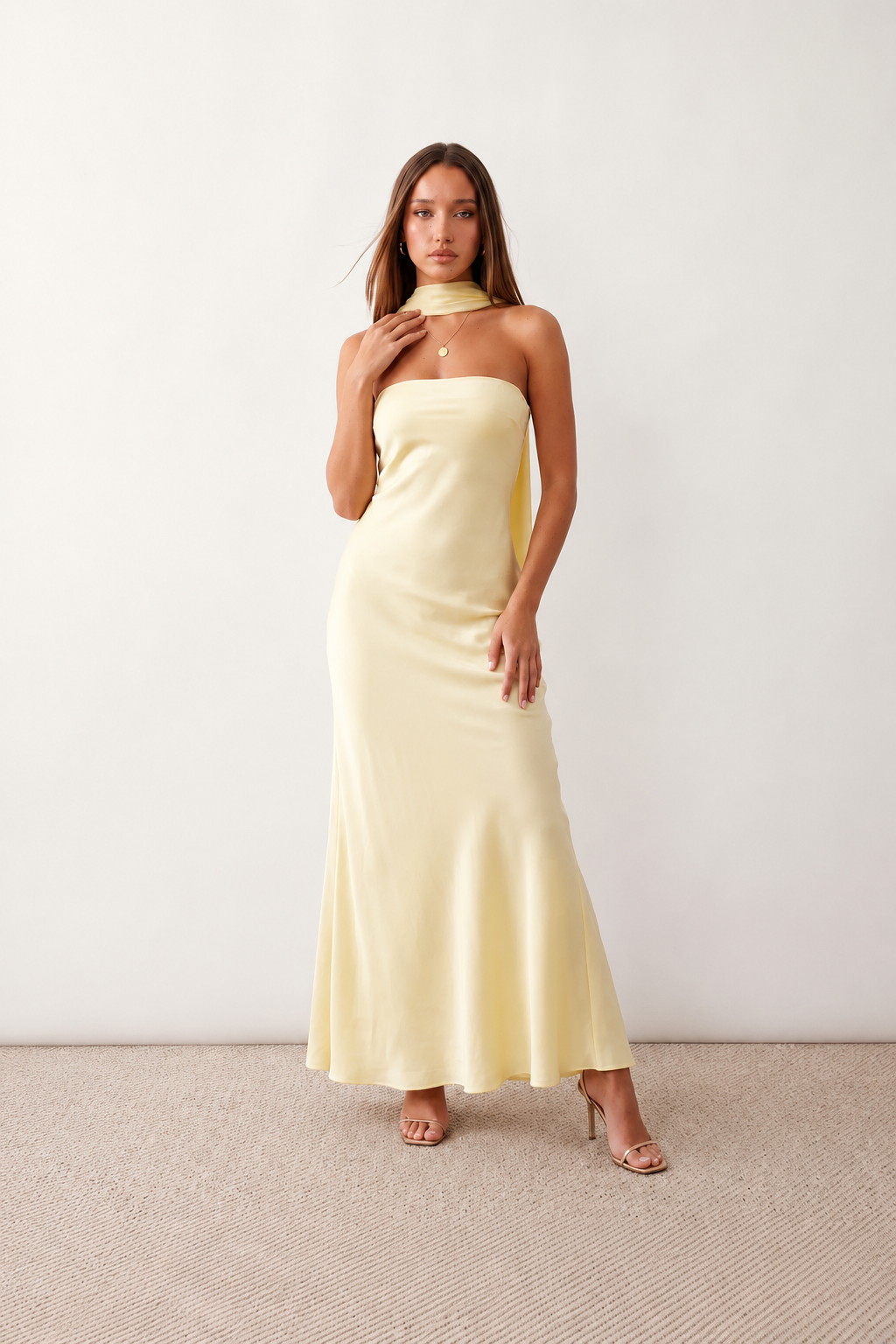 Woman wearing the Diana satin strapless maxi dress featuring a square neckline, scarf-style choker tie, open back with draped detail, and a floor-length fitted silhouette in a smooth satin finish.