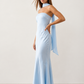 Woman wearing the Diana satin strapless maxi dress featuring a square neckline, scarf-style choker tie, open back with draped detail, and a floor-length fitted silhouette in a smooth satin finish.