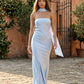 Woman wearing the Diana satin strapless maxi dress featuring a square neckline, scarf-style choker tie, open back with draped detail, and a floor-length fitted silhouette in a smooth satin finish.