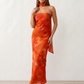 Woman wearing the Diana satin strapless maxi dress featuring a square neckline, scarf-style choker tie, open back with draped detail, and a floor-length fitted silhouette in a smooth satin finish.