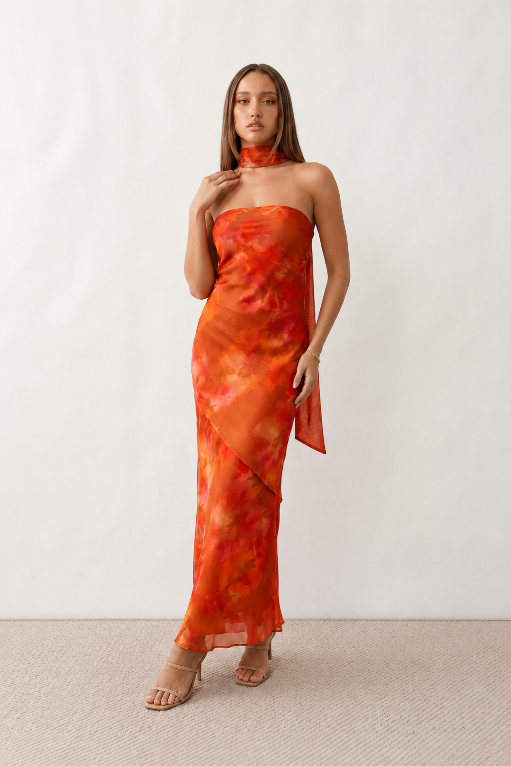 Woman wearing the Diana satin strapless maxi dress featuring a square neckline, scarf-style choker tie, open back with draped detail, and a floor-length fitted silhouette in a smooth satin finish.