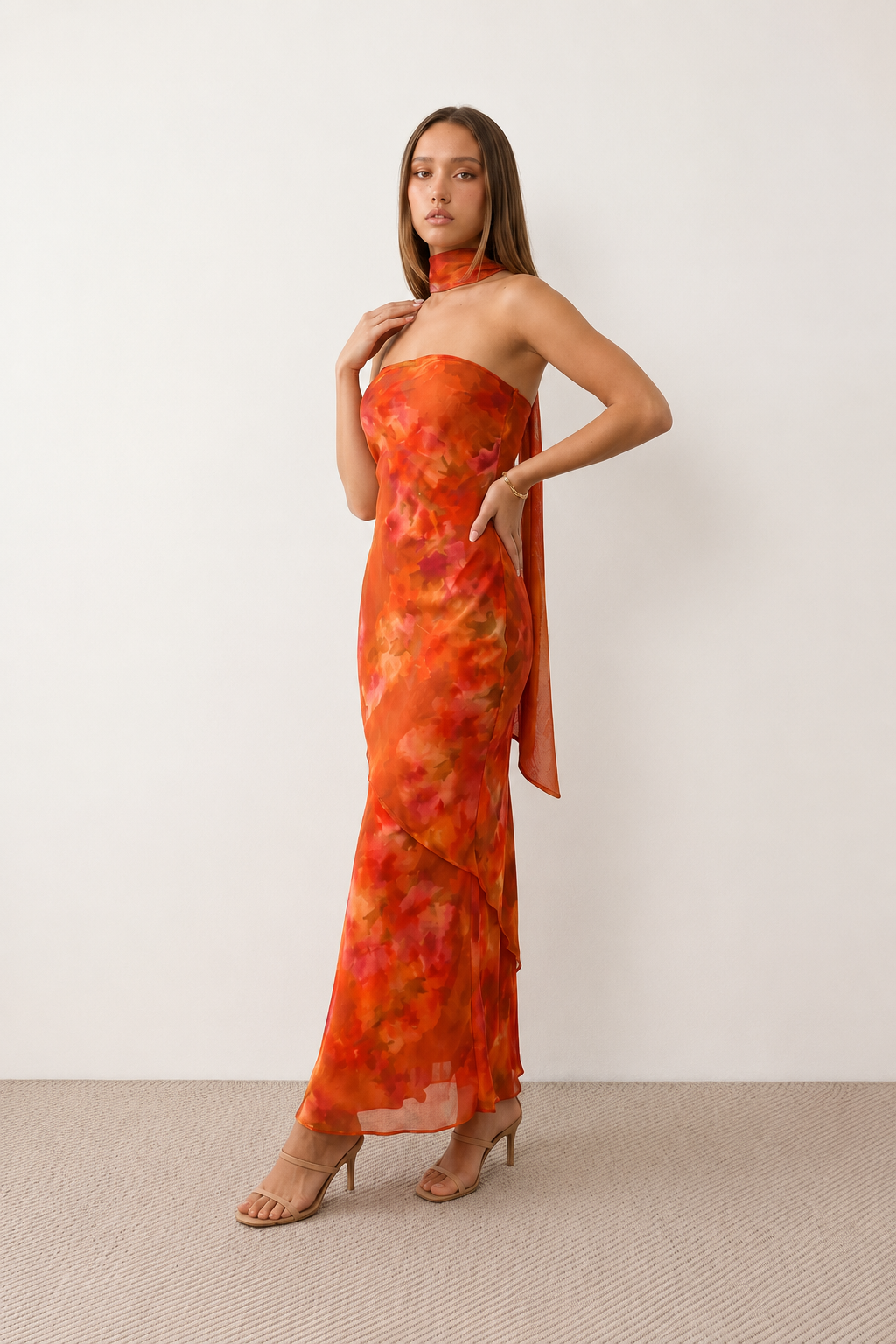 Woman wearing the Diana satin strapless maxi dress featuring a square neckline, scarf-style choker tie, open back with draped detail, and a floor-length fitted silhouette in a smooth satin finish.