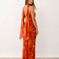 Woman wearing the Diana satin strapless maxi dress featuring a square neckline, scarf-style choker tie, open back with draped detail, and a floor-length fitted silhouette in a smooth satin finish.