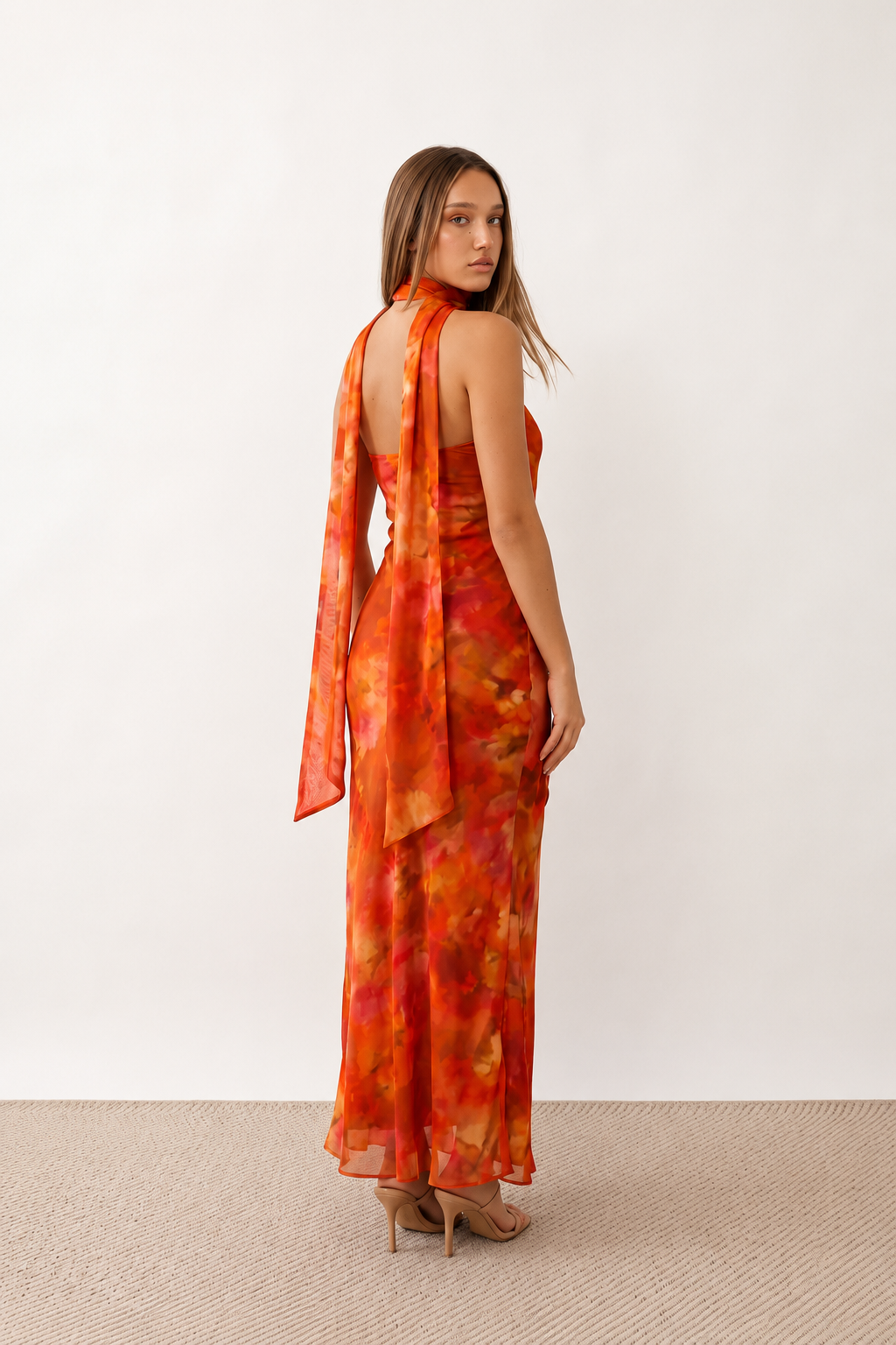 Woman wearing the Diana satin strapless maxi dress featuring a square neckline, scarf-style choker tie, open back with draped detail, and a floor-length fitted silhouette in a smooth satin finish.